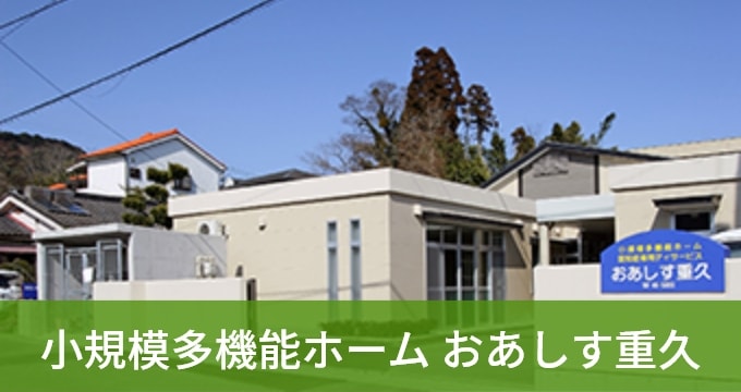 白を基調とした現代的な介護施設の建物外観。晴天の日中に撮影。